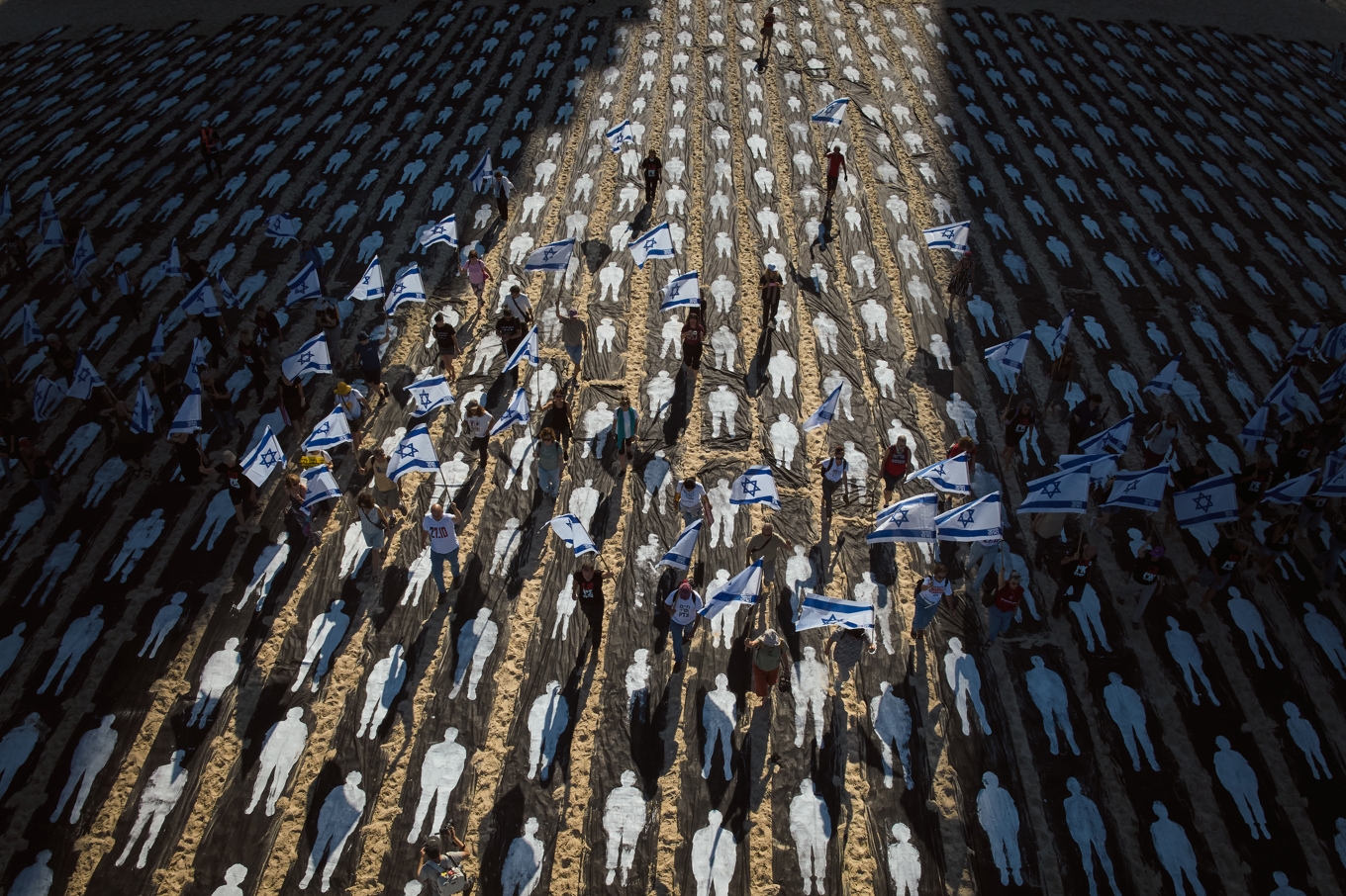 En installation på stranden Trumpeldor i Tel Aviv på den tredje årsdagen för 7 oktober-attacken. Silhuetterna representerar de runt 1 200 människor som dödades i Israel under attacken 2023. Foto: Oded Balilty/AP/TT