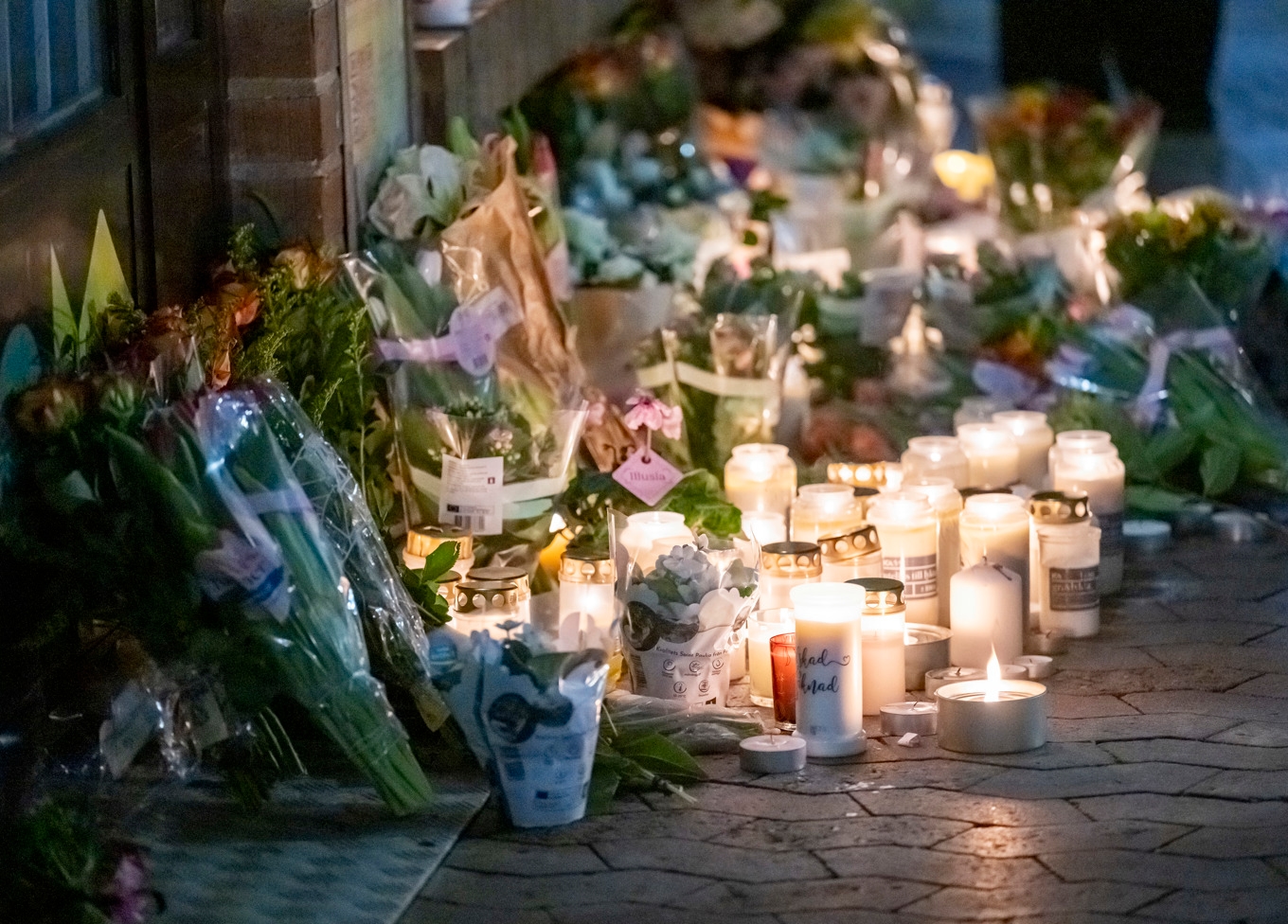 Blommor och ljus vid en butik på Bellevuegården i Malmö på onsdagskvällen efter att en kvinna i 50-årsåldern knivhuggits till döds på förmiddagen. Foto: Johan Nilsson/TT