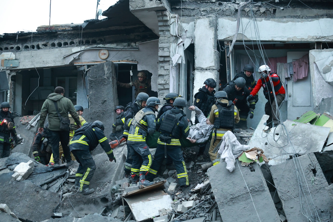 Räddningsarbetare hjälper en kvinna ur rasmassorna i Zaporizjzja. Foto: Kateryna Klochko/AP/TT