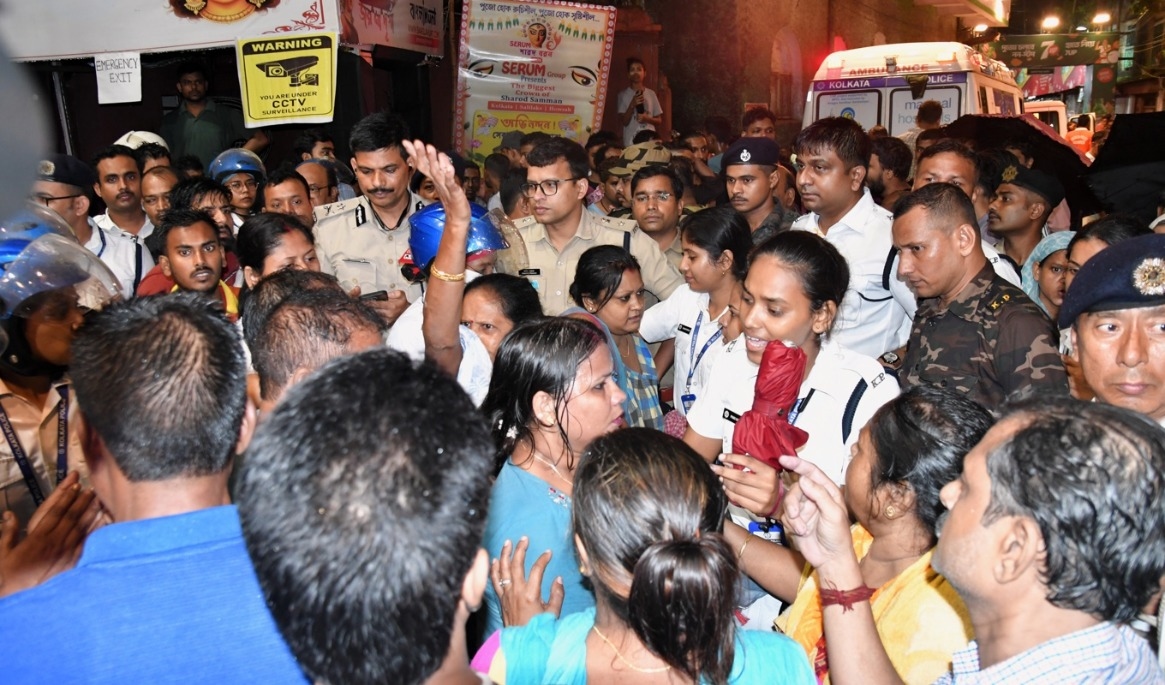 Människor samlas vid ingången till den hinduiska festival i Calcutta där minst 17 personer omkom när panik utbröt vid ett skyfall. Foto: STR/AP/TT