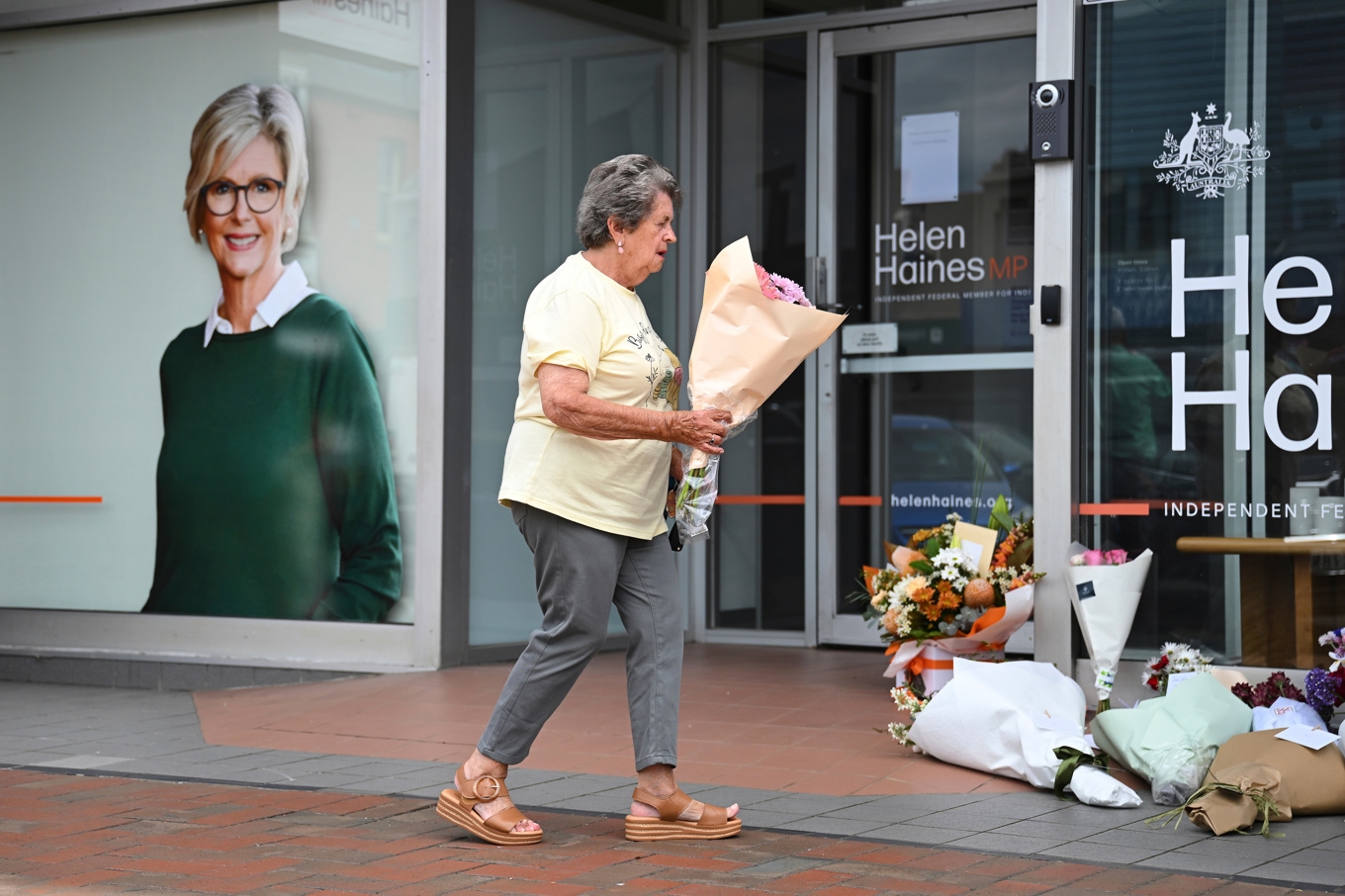 Många lämnar blommor och visar sitt deltagande vid Helen Haines kontor efter dådet i Wangaratta. Foto: James Ross/AAP/AP/TT