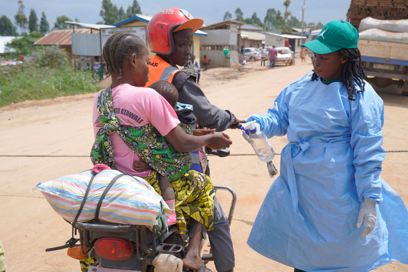 En hälsoarbetare sprejar förbipasserande med desinfektionsmedel vid en vägspärr mellan provinserna Ituri och Norra Kivu i Kongo-Kinshasa. Bild från i fredags. Foto: Dieudonne Dirole/AP/TT