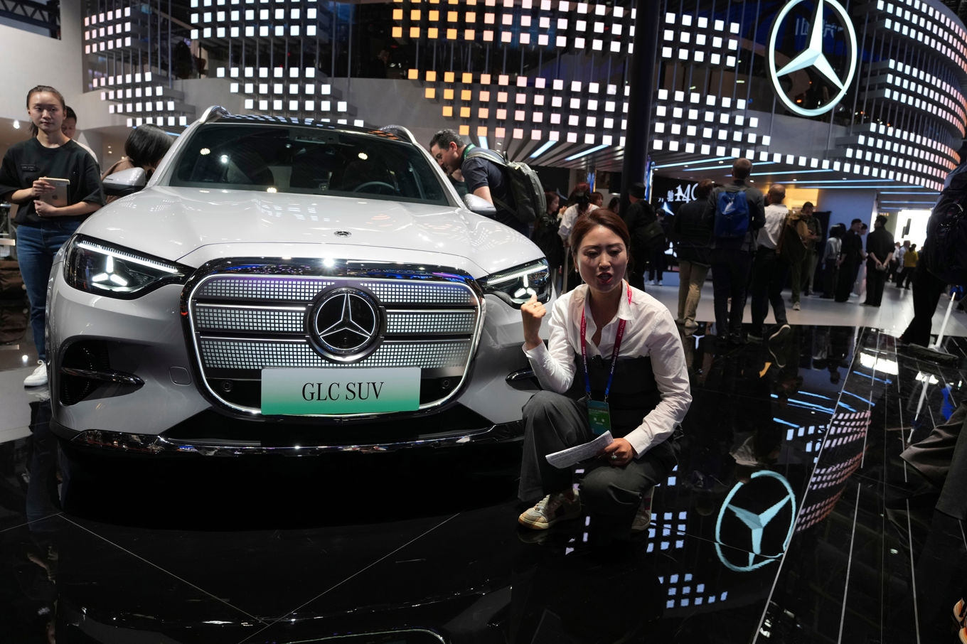 En influerare pratar om en SUV från Mercedes-Benz på en bilmässa i Kinas huvudstad Peking i april i år. Arkivbild. Foto: Ng Han Guan/AP/TT