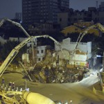 Stora maskiner används för att fylla igen ett slukhål som raserade flera byggnader i närheten av ett tunnelbanebygge i Guangzhou, Guandogprovinsen i södra Kina, den 28 januari 2013. (Foto: STR/AFP/Getty Images)