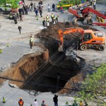 Ett slukhål som bildats under natten till den 26 april 2011 på Shiliuzhuang Road i Peking fylls igen. En del av vägen kollapsade under en lastbil. Föraren och en passagerare blev lätt skadade. Båda kunde hoppa ur bilen innan den sjönk i hålet. (Foto: STR/AFP/Getty Images)