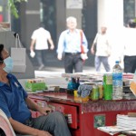 En gatuförsäljare har täckt näsa och mun under den värsta smogen som Singapore upplevt. Smogen är ohälsosam när mätaren har nått upp till 152. (Foto: Roslan Rahman /AFP)