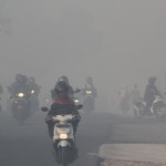 Indonesiska motorcyklister tar sig fram genom smogen i Pekanbaru, huvudstaden i Riau-provinsen på Sumatra den 20 juni. Singapore kräver av Indonesien att de ska vidta åtgärder mot bränderna som rasar på Sumatra. (Foto: Hafiz Alfarissi/AFP)