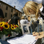 En kvinna skriver i kondoleansboken till Luciano Pavarotti den 7 september 2007 framför "Duomo di Modena" i Modena.  (Foto: Giuseppe Cacace /AFP)