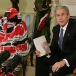 USA, Washington: Presidenten George W.Bush håller boken “Tears of The Desert” skriven av läkaren Halima Bashir, aktivist för mänskliga rättigheter i Darfur, på ett möte i Vita Huset den 10 december. Bashir täckte sig med kläder för att hålla sitt utseende hemligt av rädsla för repressalier. (Foto: Chris Kleponis/AFP
