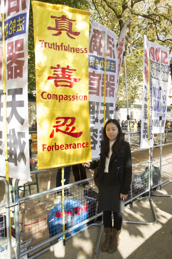 Minghui Yu, falungongutövare, med en banderoll med falungongs principer: sanning, godhet, tålamod. "Vi vill att Xi ser oss och vet att vi är här och väntar på att han ska förändra saker och ting. Jag hoppas verkligen att han kan lyssna på sitt folk." (Si Gross/Epoch Times)