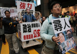 Människor demonstrerar i Hongkong i protest mot de försvunna bokförläggarna, bland dem svensken Gui Minhai. (Foto: Vincent Yu/AP/TT-arkivbild)