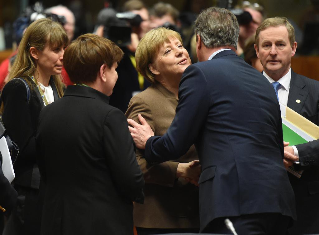 Tysklands Angela Merkel hälsar på Storbritanniens David Cameron under torsdagens sena förhandlingar i Bryssel. (Foto: Geert Vanden Wijngaert /AP/TT)