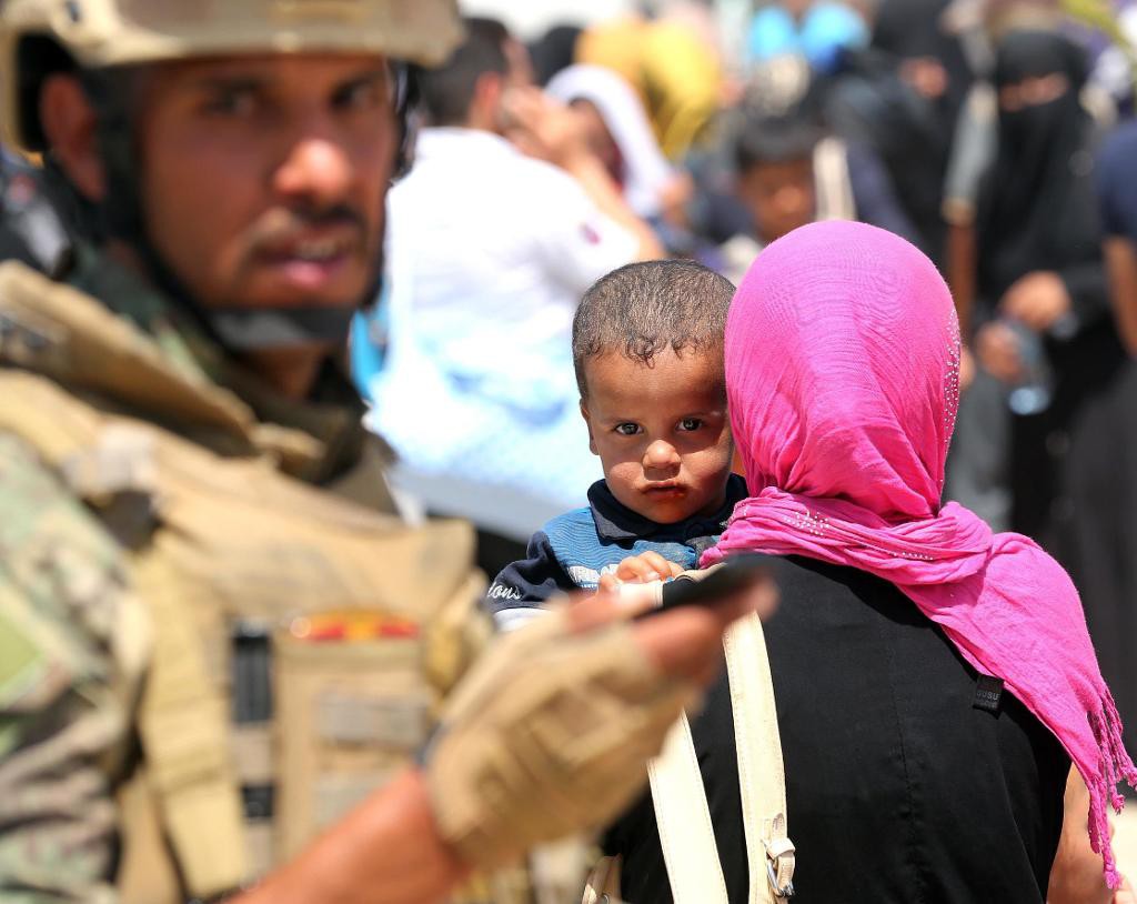 En irakisk soldat står vakt vid ett flyktingläger utanför al-Falluja i Irak. (Foto: Hadi Mizban /AP/TT-arkivbild)