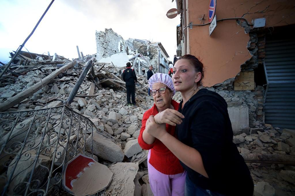 Människor i byn Amatrice flyr ut ur de rasade husen. (Foto: Filippo Monteforte)