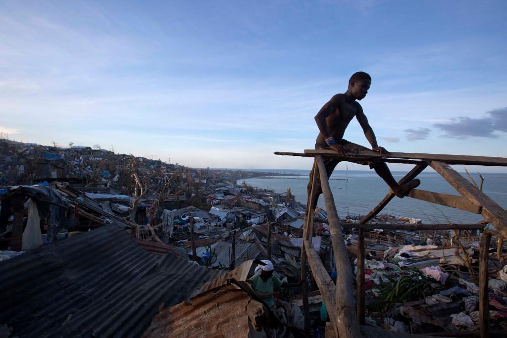 En man försöker att reparera sitt tak som blåsts bort av Matthew. (Foto: Dieu Nalio Chery/AP/TT)