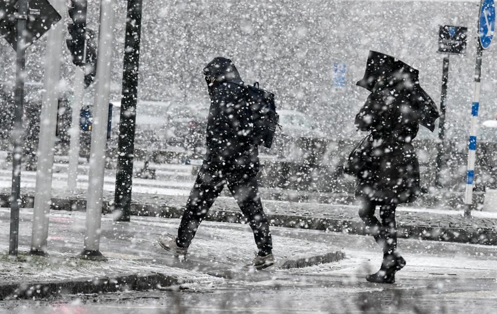 Gående i det ymniga snöfallet i Malmö vid lunchtid på onsdagen. (Foto: Johan Nilsson / TT)