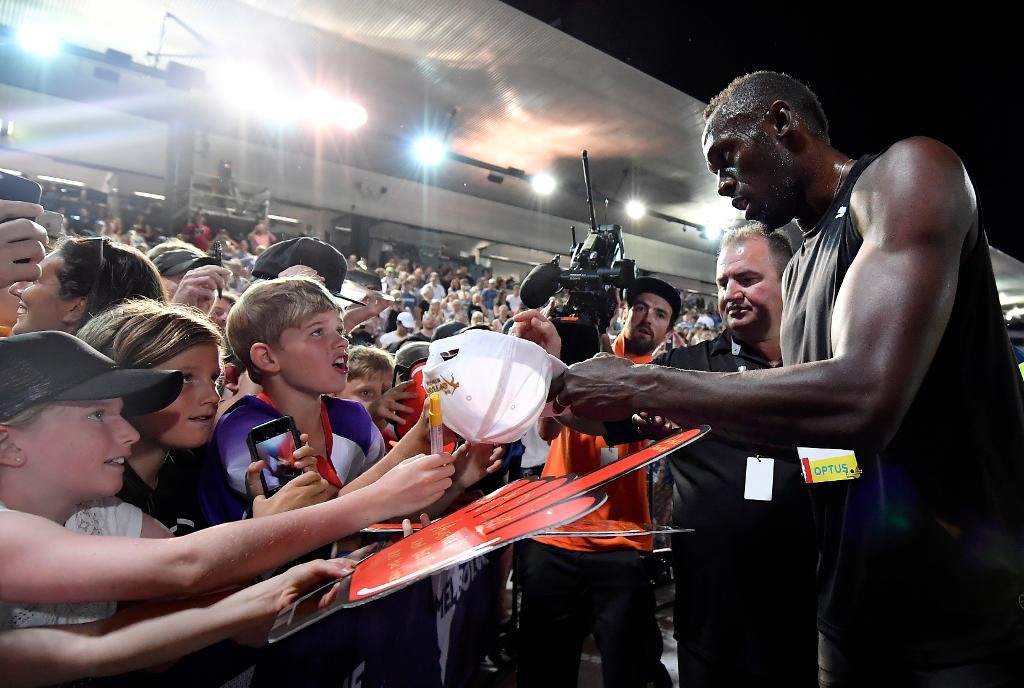 Usain Bolt skriver autografer under Nitro Athletics i Melbourne. Foto: Andy Brownbill /AP/TT