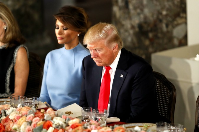 USA:s president Donald Trump och hans fru Melania ber under invigningslunchen i Kapitolium i Washington, efter att ha svurits in som president. Foto: Aaron P. Bernstein/Getty Images