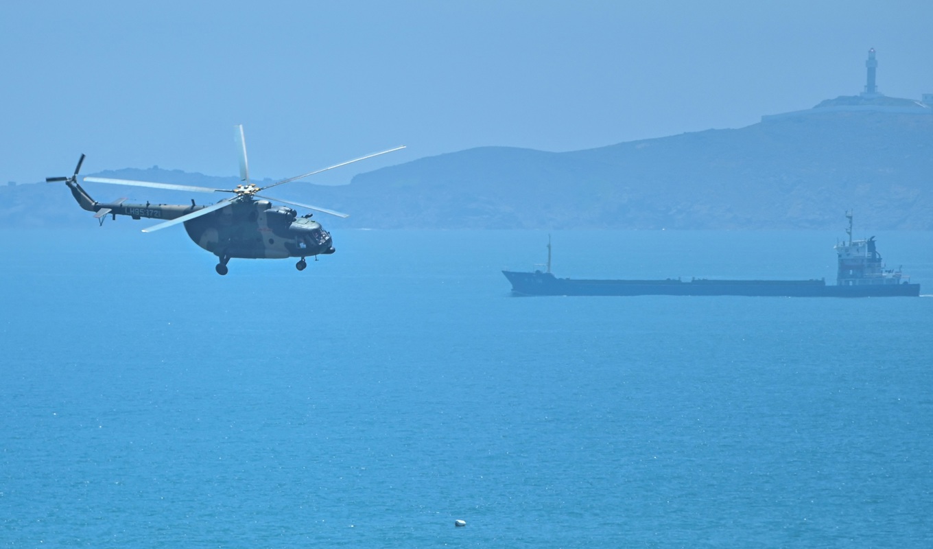 En kinesisk militärhelikopter flyger över Pingtan i närheten av Taiwan den 4 augusti 2022. Foto: Hector Retamal/AFP via Getty Images