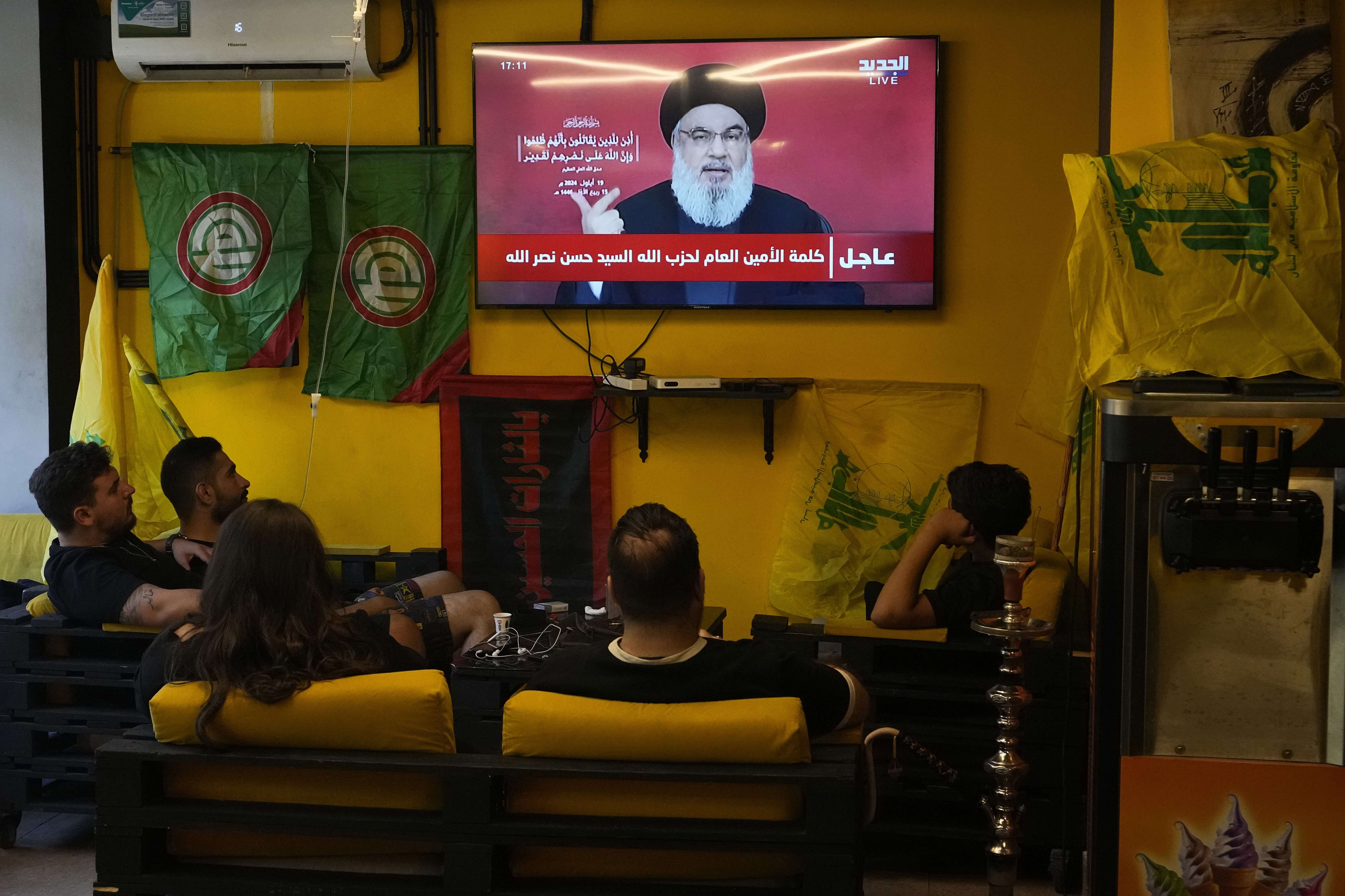 Hizbollah-ledaren Hassan Nasrallahs tal på torsdagen visas på ett café i Beiruts södra förorter, där stödet till shiamilisen är stort. Foto: Hassan Ammar/AP/TT