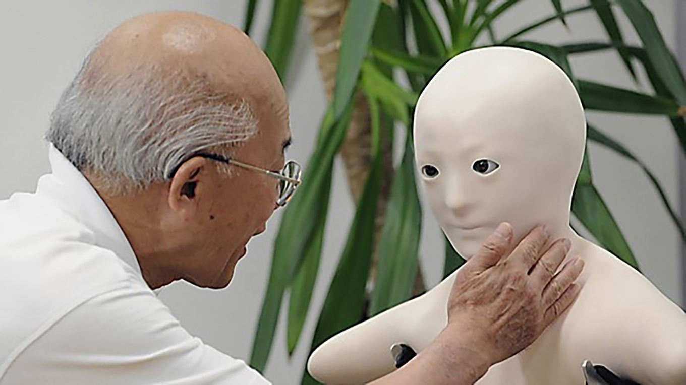 En äldre japansk man kommunicerar med sitt barnbarn via en människoliknande robot. Foto: Yoshikazu Tsuno/AFP via Getty Images