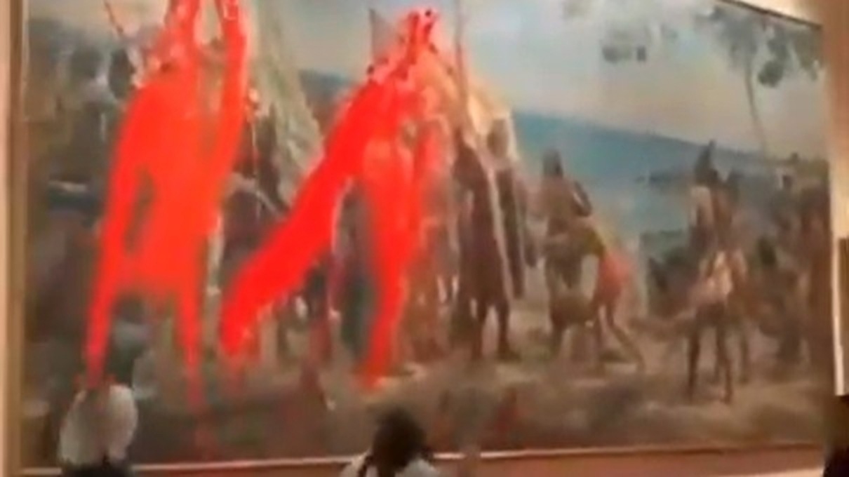 Två kvinnor kastade röd färg på en tavla som föreställer Christopher Columbus. Foto: Futuro Vegetal/Skärmdump/X